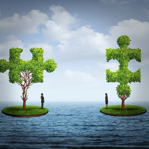 Two islands of grass with tree leaves forming puzzle pieces on the ocean, man and woman on each island face each other.